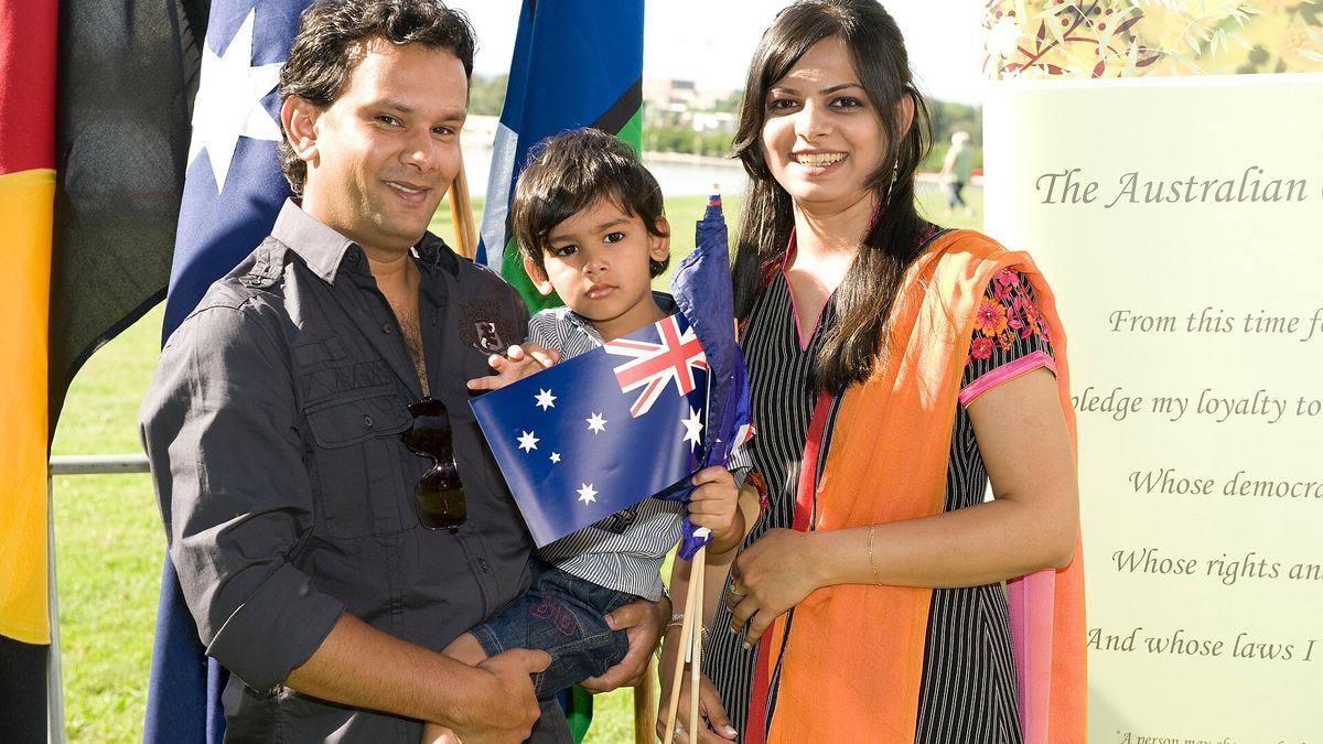 A family holding Australian flags at an Australia Day citizenship ceremony